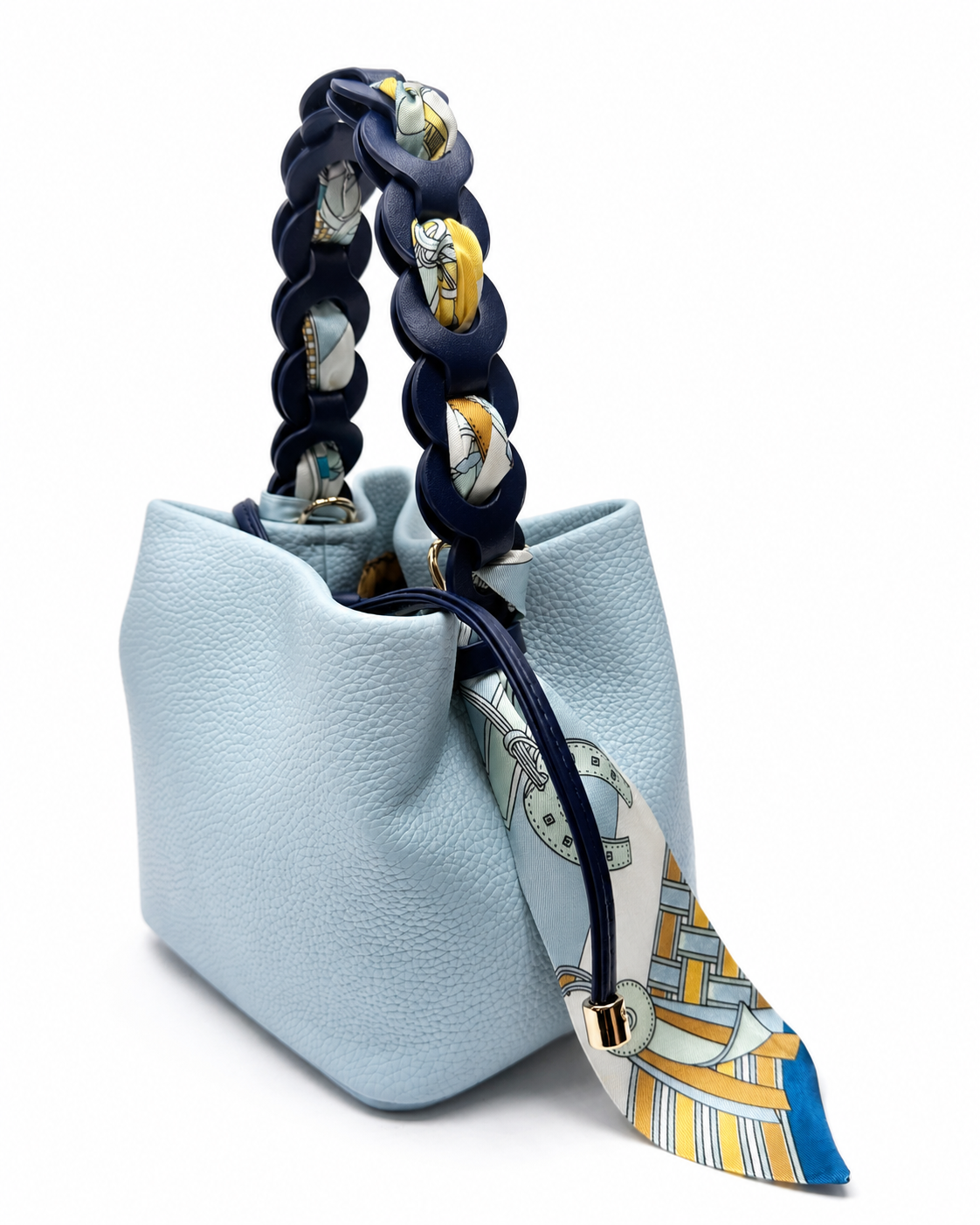 Blue pebble-grain bucket bag with a chain handle woven with a printed scarf, on a white background