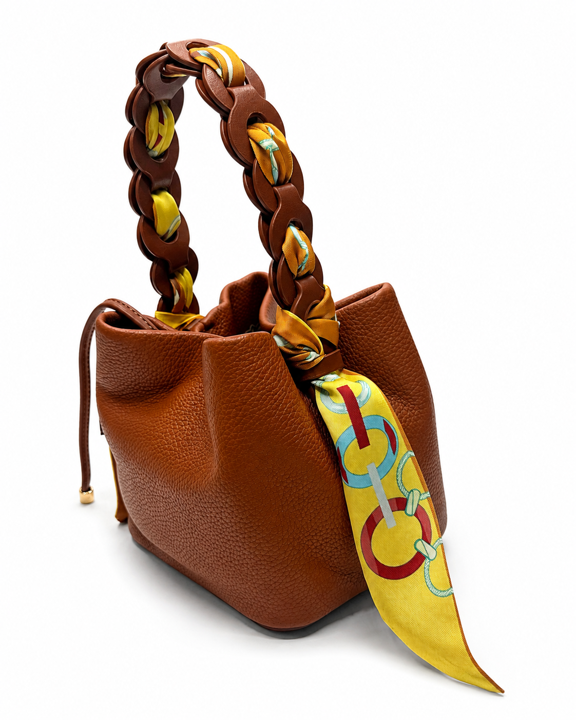 Brown pebble-grain bucket bag with a chain handle woven with a printed scarf, on a white background