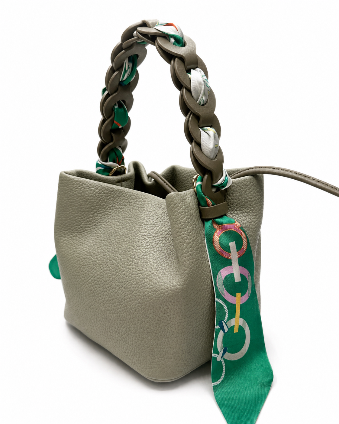 Green pebble-grain bucket bag with a chain handle woven with a printed scarf, on a white background