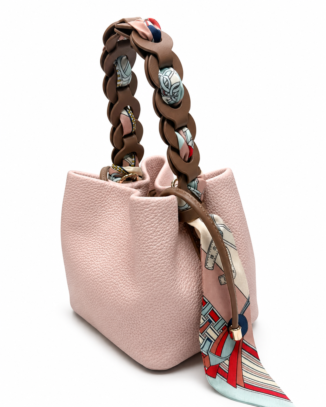 Pink pebble-grain bucket bag with a chain handle woven with a printed scarf, on a white background