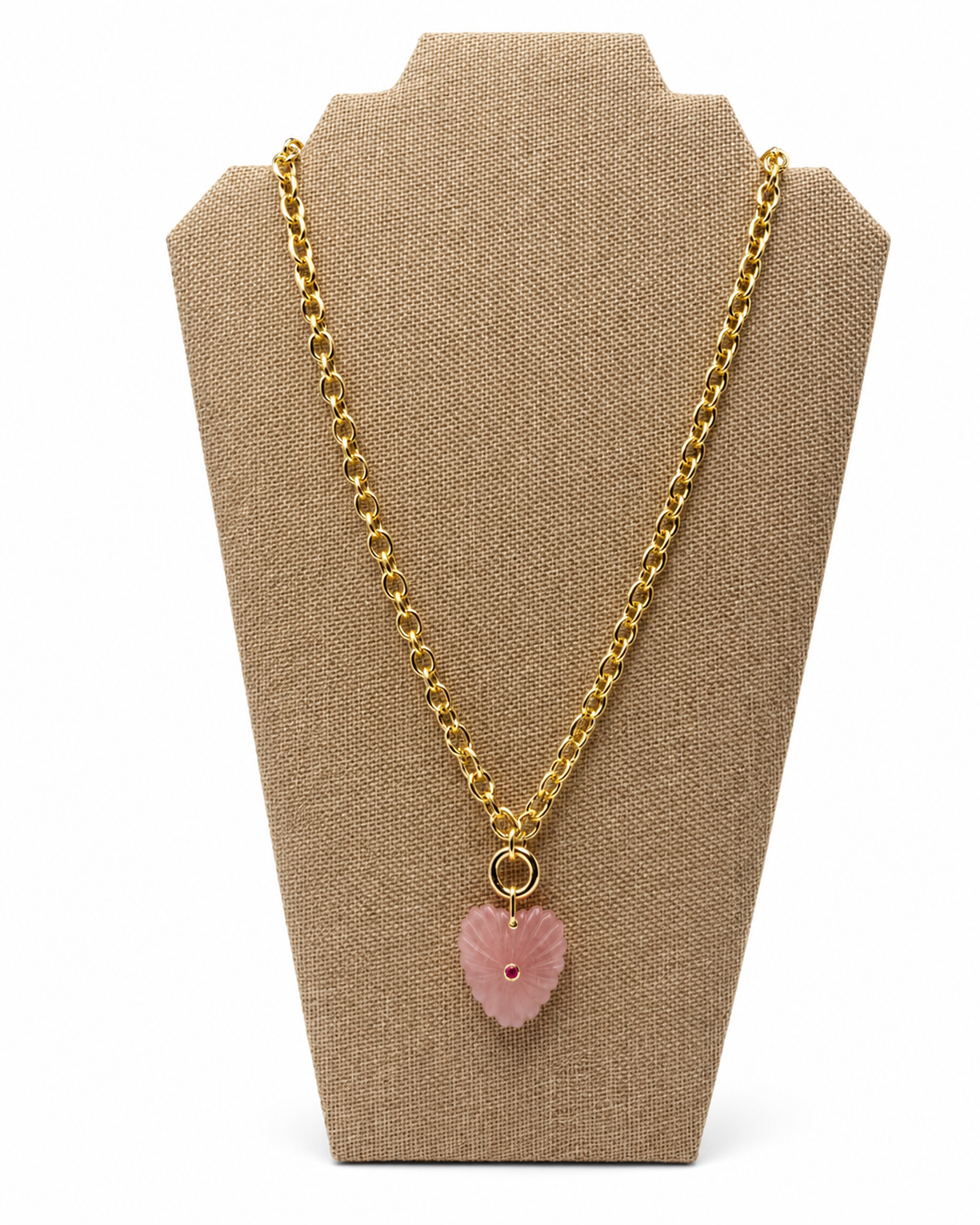 Long gold-tone chain necklace with a pink heart pendant set with a red stone, on a white background